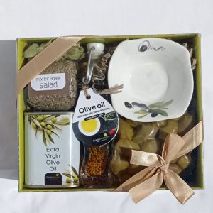 Gift box with virgin olive oil, olive oil with herbs, olives, bowl and mix for salad